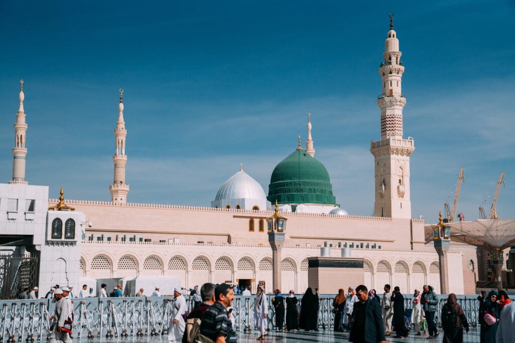 Urban view of Prophet's Mosque, Medina during day with minarets and people.