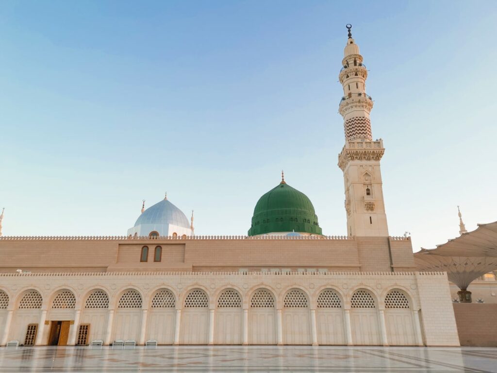 Iconic view of the Green Dome and minaret at Al-Masjid an-Nabawi, Medina, during daytime.