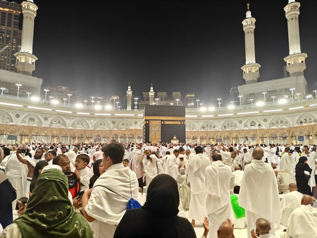 Night view of pilgrims gathered around the Kaaba in Mecca, Saudi Arabia during Hajj.